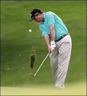 Olin Browne kicks up some turf while hitting on the #8 fairway during the second round of the U.S. Senior Open.