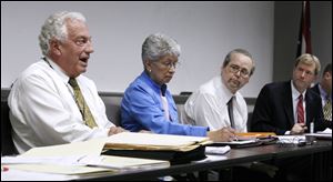 Ron Rothenbuhler addresses fellow board members Rita Clark, Anthony DeGidio, and Jon Stainbrook, right. The board went into executive session at its meeting Friday to discuss employee cuts.