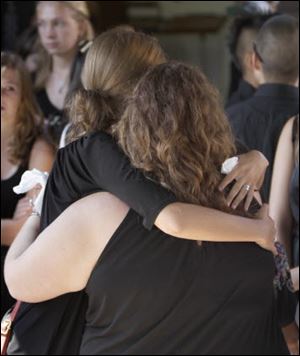 Two women embrace in Barling, Ark., Saturday after a service for four of the five victims of a shooting rampage last weekend at a Grand Prairie, Texas roller rink. 