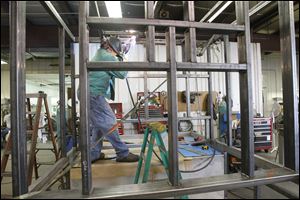 Paul DeLisle welds a wash system at Met-L-Tec in Temperance, a company that has cultivated customers outside its automotive base.