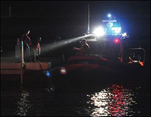 A Coast Guard vessel, which was in the area when the crash was reported, arrives at the docks to bring a victim onto Catawba Island. 