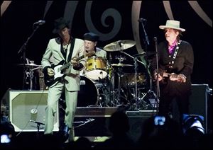 Bob Dylan , right,  performs with his band, including guitarist Charlie Sexton, left, at a concert in Vietnam this past April.