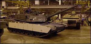 An M1 A2 tank is driven out of the Test and Acceptance facility by mechanics at the Army tank plant in Lima, Ohio.