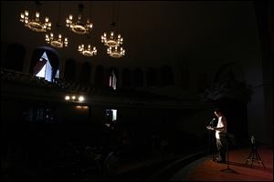 Zack Moll of Norwalk is spotlighted as he reads one of his poems during Toledo’s largest poetry event in decades.