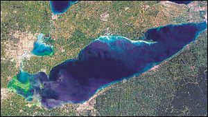 This satellite photo shows an algae bloom, in green coloration at left, that continues to grow eastward over a section of Lake Erie.
