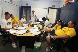 From left, assistants Justin Keller, Brad Densmore, Ron Martin, Ken Winters, Wondell Hill, Mike Williams, and Jerry Bell spend a lot of their day together. Coaches arrive to camp at 6:45 a.m. and usually leave close to 6 at night.