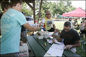 Cory Strange of Millington, Mich., left receives his race number from Ron Toneff as he is registered by Scott Main. 