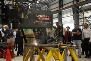 A robotic welding machine is shown during a demonstration at the dedication of Ventower Industries Tuesday.