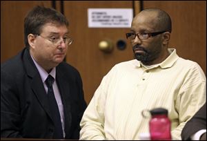Defense attorney John Parker, left, talks with Anthony Sowell during court proceedings July 19.