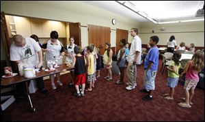 Participants in the youth summer reading program line up for hot dogs, chips, and ice cream sundaes during a celebration recognizing their achievements. About 19,000 people of all ages participated in the summer programs. 