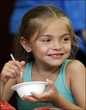 Alayna Avalos, 6, enjoys a bowl of ice cream during a party to celebrate the final chapter in the nine-week-long 2011 reading club at Locke Branch Library on Miami Street in East Toledo.