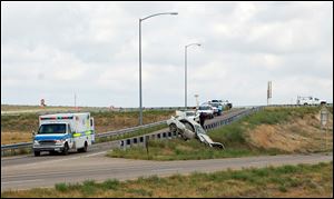 This Photo provided by Huerfano Journal, shows a car that was driven by three fugitive siblings crashed on a highway barrier Wednesday in Walsenburg, Colo.