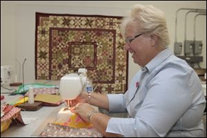 Rita Thomas, a Sylvania resident and quilter who will be making the trip to Joplin this month, stitches quilt pieces together at the group's workshop.