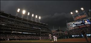 Storm clouds form over the field in the second inning of a baseball game between the Cleveland Indians and the Detroit Tigers in Cleveland Tuesday. The rain came and the game went on a rain delay.