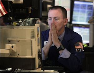 Specialist James Ahrens works at his post on the floor of the New York Stock Exchange Wednesday. Wall Street focused on the bleak landscape ahead for the economy and sold off, wiping out the big gains from a day earlier and then some.
