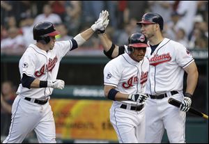 Cleveland's Jason Kipnis, left, is congratulated by Travis Hafner after hitting a two-run home run and driving in Ezequiel Carrera, center.