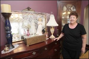 Betty Metz displays various items she has purchased from secondhand stores in her Oregon home.