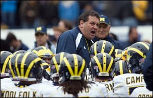 Michigan head coach Brady Hoke, center, speaks to his team after their spring NCAA college football game at Michigan Stadium in Ann Arbor, Mich. Michigan hired a husky coach with a raspy voice, hoping Ohio native Brady Hoke, who grew up rooting for the Wolverines, can restore college football's winningest program to glory after losses on and off the field led to Rich Rodriguez's ouster after just three seasons.