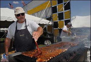 'Brisket Bob' Ledvina slathers on the sauce to his ribs as they sizzle on the grill at the Pig's Foot booth, one of nine at the 28th Northwest Ohio Rib-Off at the Lucas County Fairgrounds in Maumee.