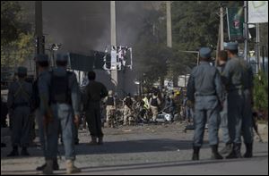 Afghan security forces, center, inspects the site of a suicide attack outside The British Council in Kabul, Afghanistan, Friday.
