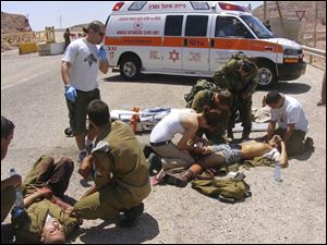 Wounded Israeli soldiers are treated at the site of a shooting attack. Gunmen crossed into Israel from neighboring Egypt Thursday and set up an ambush, the military says.