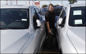Jason Ashton looks at a 2012 Dodge Durango at a dealership in Warren, Mich. But the 38-year-old says he's holding out for a price that won't raise his payments and will spend less on options than in the past.