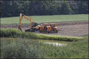Equipment is ready to fix the slumping  embankment along the turnpike near bridges over State Rt. 19 and the Norfolk Southern railroad west of Fremont's Interchange 91. Work began this month.