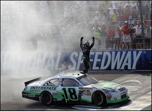 Kyle Busch celebrates with his fans after getting the victory in the Pure Michigan 400 Monday at Michigan International Speedway.