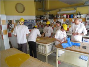 Students prepare tortellini and tortelloni at La Vecchia Scuola pasta school in Bologna, Italy.