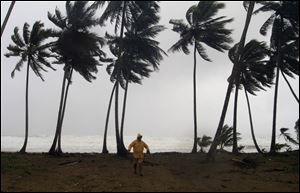 A man walks away from Los Yayales beach after watching the sea surge due to the approach of Hurricane Irene to Nagua, in the northern coast of the Dominican Republic, Monday, Aug, 22, 2011. A strengthening Category 2 Hurricane Irene roared off the Dominican Republic's resort-dotted northern coast on Monday night, whipping up high waves and torrential downpours on a track that could slam it into the U.S. Southeast as a major storm by the end of the week.