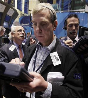 In this Aug. 19, 2011 photo, trader Richard Cohen, foreground center, on the floor of the New York Stock Exchange.