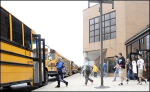Woodmore High School students board their buses in front of the school in April.