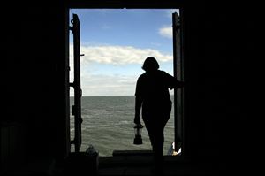 Sandy Bihn, president of the Toledo Harbor Lighthouse Preservation Society, looks out at the water from the lighthouse’s lower level. She says the lighthouse is in good shape — and preservationists aim to keep it that way.