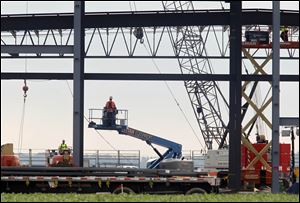 A worker uses a lift to reach a steel frame being erected at the Vehtek expansion project in Bowling Green.