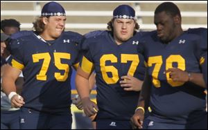 Greg Mancz, left, and Zac Kerin, center, will be the only nonseniors on the Rockets’ offensive line this season. Phillipkeith Manley, right, played left guard last season.