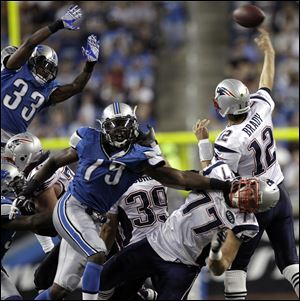 New England Patriots quarterback Tom Brady throws under pressure from Lions defensive end Willie Young (79), and cornerback Brandon McDonald jumps to block Brady’s pass Saturday night.
