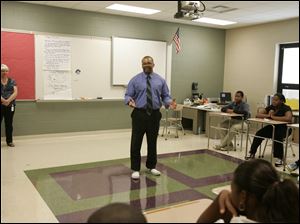 Principal Anthony Bronaugh, right, having changed into sneakers, introduces himself, the assistant principal, Geralyn Demkowski, rear left,  and the counselor [not pictured] to seventh graders. Robinson Elementary School, with grades K-8, starts the school year on August 29, 2011. The school is hoping to transform itself with a new principal and with teachers who want to teach there, and who were selected on the basis of their commitment and excellence. The Blade/Jetta Fraser