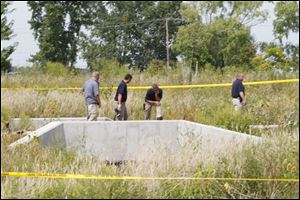 Authorities look over the area where a body was found Tuesday on North Stadium Road near Willacker Road in Oregon, Ohio.