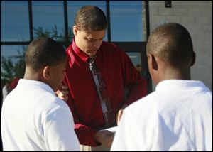 Counselor Antonio Davis helps students find where they need to go on the first day of classes at Robinson Elementary. After the school ranked last in the district on standardized tests last year, TPS overhauled the entire staff.