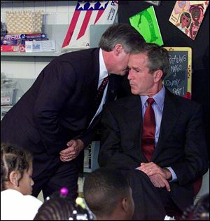 Chief of Staff Andy Card whispers into the ear of President George W. Bush to give him word of the plane crashes into the World Trade Center, during a visit to the Emma E. Booker Elementary School in Sarasota, Fla. 