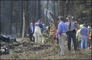 Firefighters and emergency personnel investigate the fatal crash scene of Flight 93 in Shanksville, Pa.