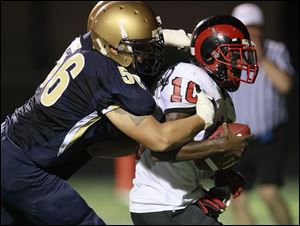 St. Johns' Matt Miller, left, sacks Rogers quarterback D.J. Tucker during the preseason Shoe Bowl games held on Aug. 19.  Teams in the City League  have been outscored by an average of 37.9-8.5 during the first two weeks of the season.