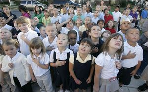 Students at Navarre Elementary School in East Toledo watch as the U.S. flag is raised in front of their school during a 2010 ceremony to remember the terrorist attacks of September 11, 2001.