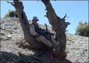 Pat Tillman rests on a tree in Afghanistan.