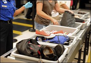 Airline passengers retrieve their scanned belongings while going through the Transportation Security Administration security checkpoint at Hartsfield-Jackson Atlanta International Airport in Atlanta. 