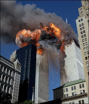 Smoke, flames and debris erupt from one of the World Trade Center towers after a plane strikes it Sept. 11, 2001. The first tower was already burning following a similar attack minutes earlier.