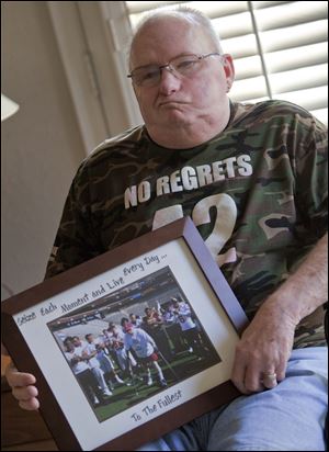 Sheldon Davidson holds a photograph of his first Pat's Run marathon in 2009 at his home in Mesa, Ariz. The 60-year-old war veteran described his first attempt at Pat’s Run after suffering a stroke is overcome with emotion as he recalls how the memory of Tillman pushed him to the finish line when his body was seemingly unable to go on.