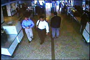 This image made from surveillance video from Washington's Dulles Airport shows two of the five hijackers on the morning of Sept. 11, 2001, man in blue shirt, left, and white shirt, second from left, leaving a security checkpoint before boarding American Airlines flight 77 that later crashed into the Pentagon.