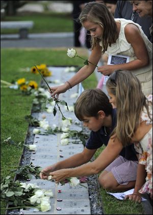 Family of loved ones lost leave roses at a memorial during a service Thursday at Sherwood Island State Park in Westport, Conn., marking the 10th anniversary of the Sept. 11, 2001, terrorist attacks that killed 152 people with ties to Connecticut.