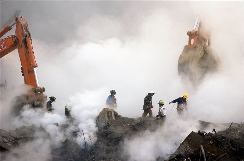 Firefighters make their way over the ruins of the World Trade Center through